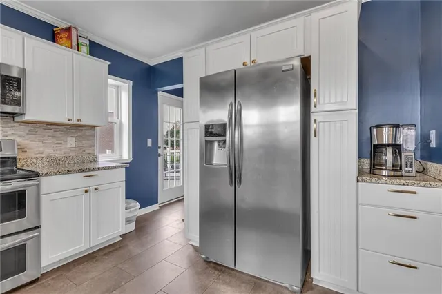 a kitchen with stainless steel appliances granite countertop a refrigerator and a stove top oven