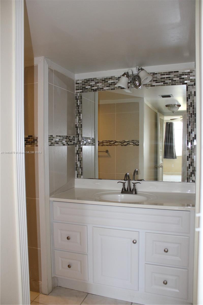 3490 Foxcroft Road, Unit B110 Miramar, FL 33025 - Photo 14 of 39 a bathroom with a double vanity sink and mirror