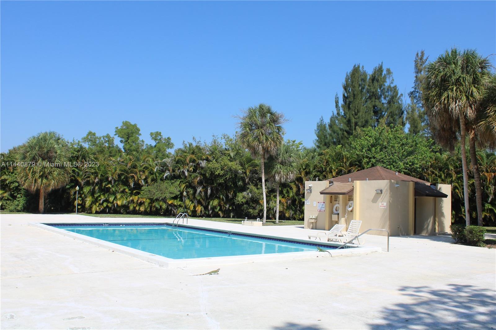 3490 Foxcroft Road, Unit B110 Miramar, FL 33025 - Photo 28 of 39 a view of a white house with a big yard and large trees