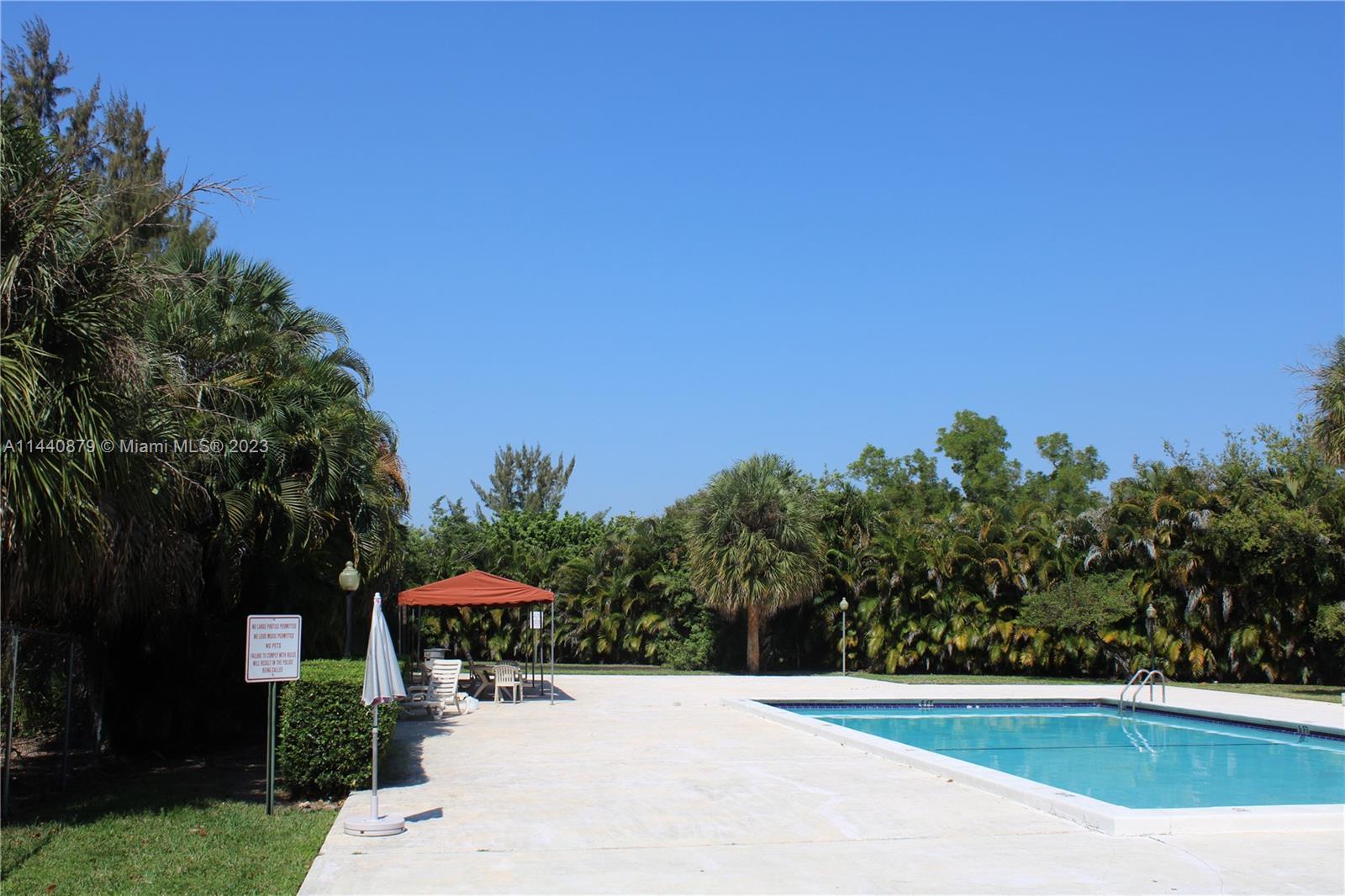 3490 Foxcroft Road, Unit B110 Miramar, FL 33025 - Photo 29 of 39 a view of a swimming pool with an outdoor seating and a garden