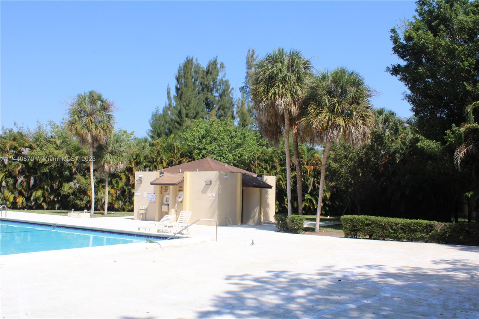 3490 Foxcroft Road, Unit B110 Miramar, FL 33025 - Photo 31 of 39 a view of a white house with a yard and palm trees