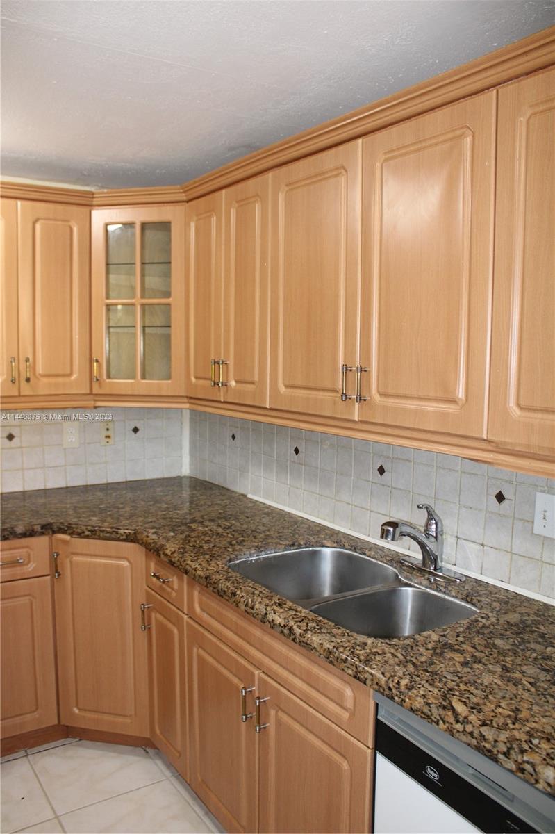 3490 Foxcroft Road, Unit B110 Miramar, FL 33025 - Photo 9 of 39 a kitchen with granite countertop white cabinets and sink