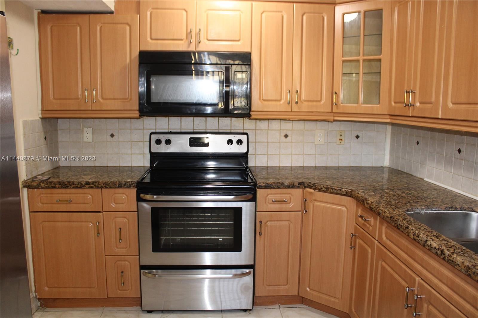3490 Foxcroft Road, Unit B110 Miramar, FL 33025 - Photo 10 of 39 a kitchen with stainless steel appliances granite countertop a stove and a microwave