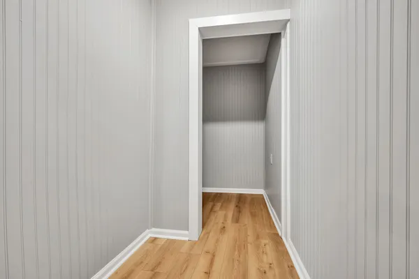 a view of a hallway with wooden floor