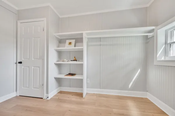 a view of an empty room with closet and a window