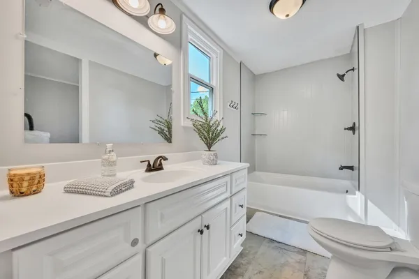 a bathroom with a granite countertop sink toilet and shower