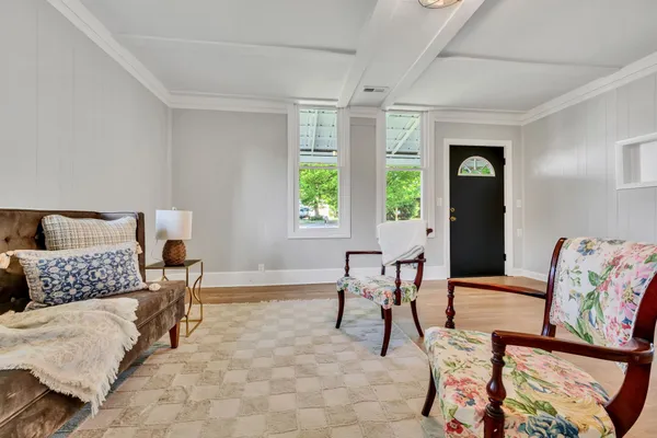 a living room with furniture and painting on the wall