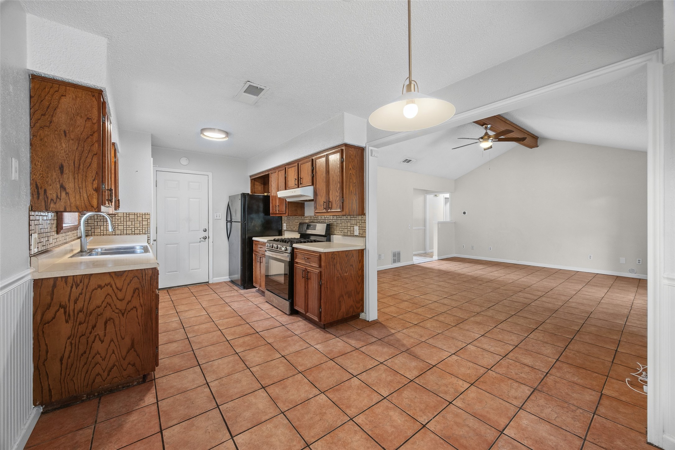 7506 Glenhill Road Austin, TX 78752 - Photo 10 of 20 A well-appointed kitchen features rich wood cabinetry, stainless steel appliances, and a seamless flow into the living area.