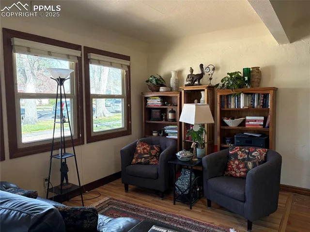 a living room with furniture a bookshelf and a window