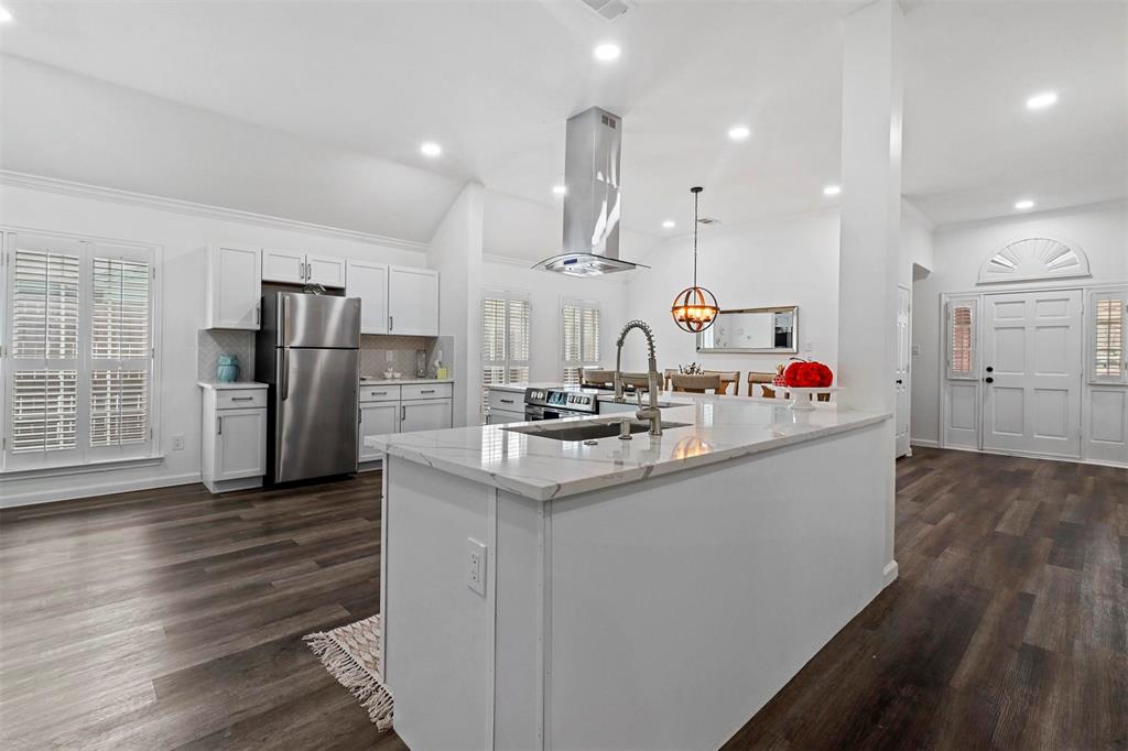 17708 Hillcrest Road Dallas, TX 75252 - Photo 7 of 27 a kitchen with stainless steel appliances kitchen island granite countertop a refrigerator and a sink