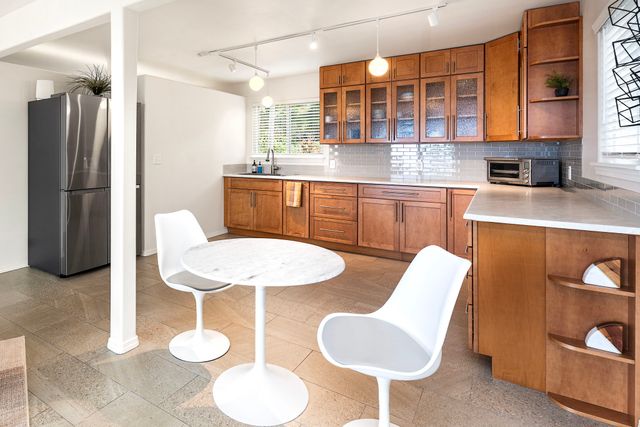 a kitchen with a table chairs and a refrigerator