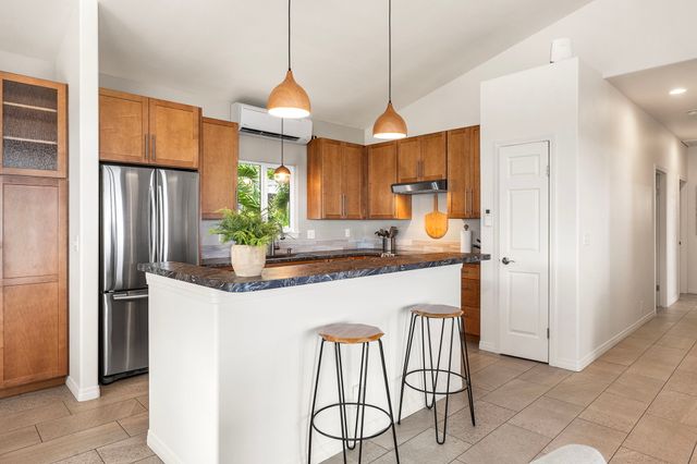 a kitchen with stainless steel appliances granite countertop a refrigerator a sink a stove and a refrigerator