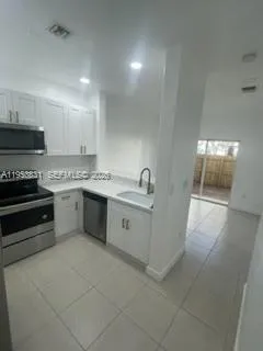 a kitchen with a stove top oven sink and cabinets