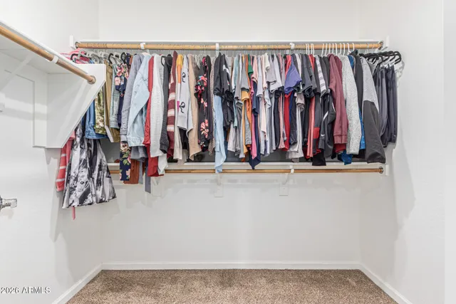 a view of walk in closet with clothes
