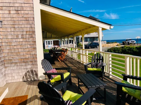 a view of a house with wooden deck and furniture