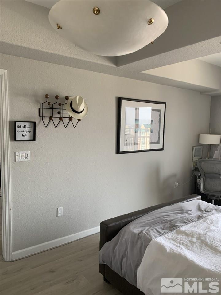 200 West 2nd Street, Unit 1502 Reno, NV 89501 - Photo 17 of 29 a bedroom with a bed and wooden floor