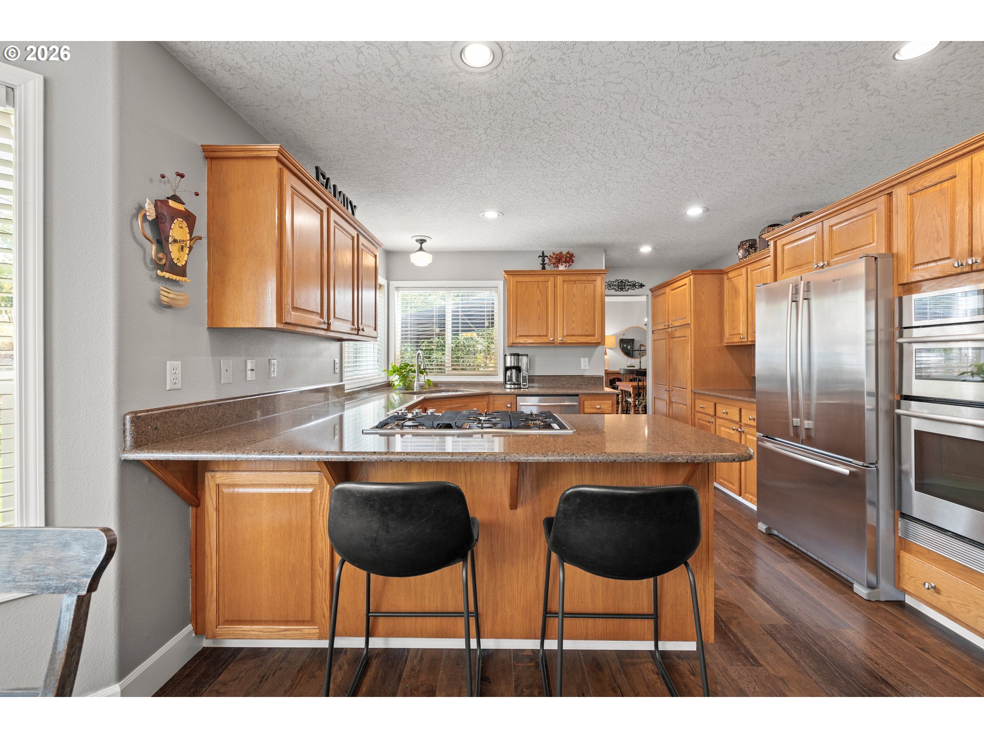 4549 Southeast 10th Terrace Gresham, OR 97080 - Photo 13 of 44 a kitchen with stainless steel appliances a dining table chairs refrigerator and sink