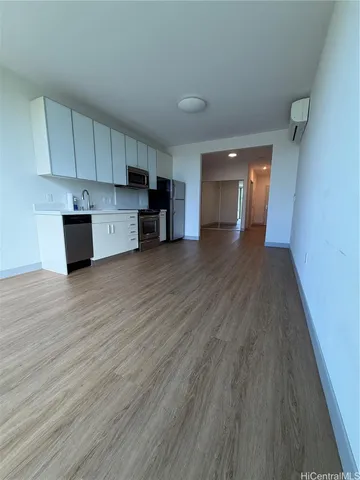a view of a kitchen with wooden floor and electronic appliances