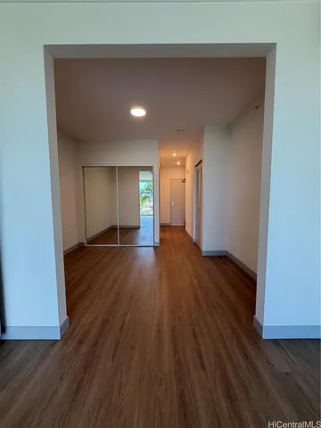 a view of empty room with wooden floor