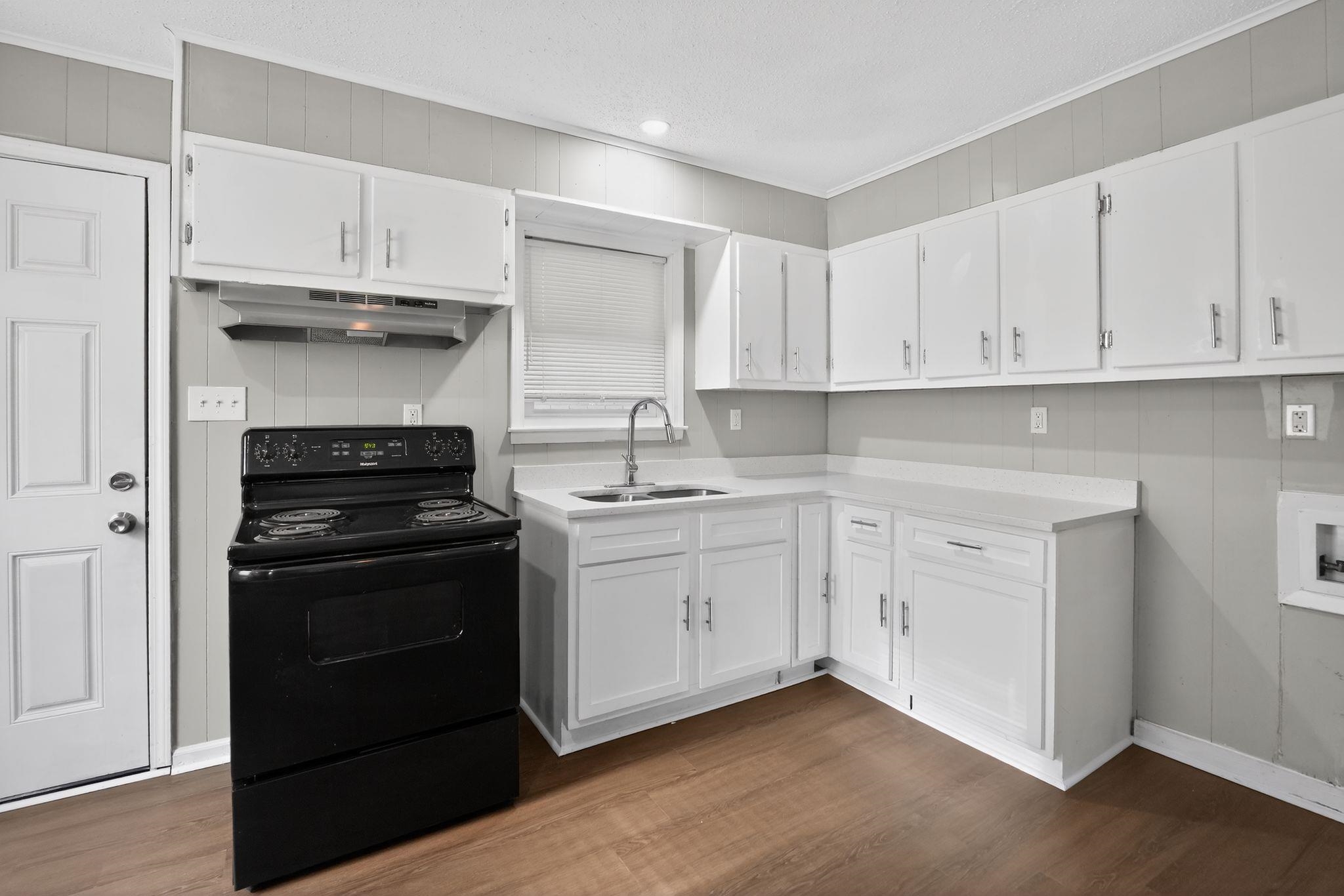 4686 Gill Road Memphis, TN 38109 - Photo 18 of 32 Kitchen featuring white cabinetry, light countertops, and a black freestanding electric range