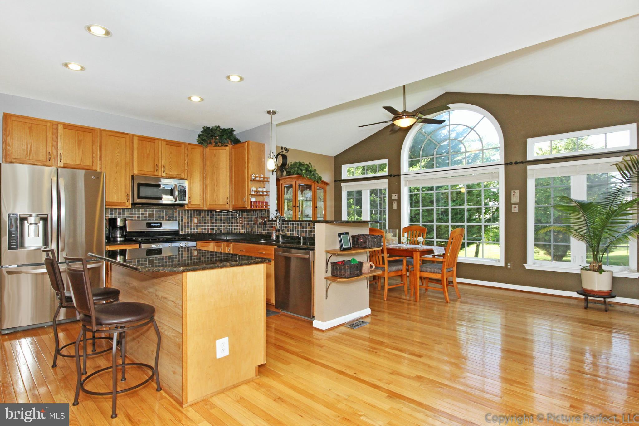 9014 Bealls Farm Road Frederick, MD 21704 - Photo 2 of 30 a kitchen with a table chairs microwave and refrigerator