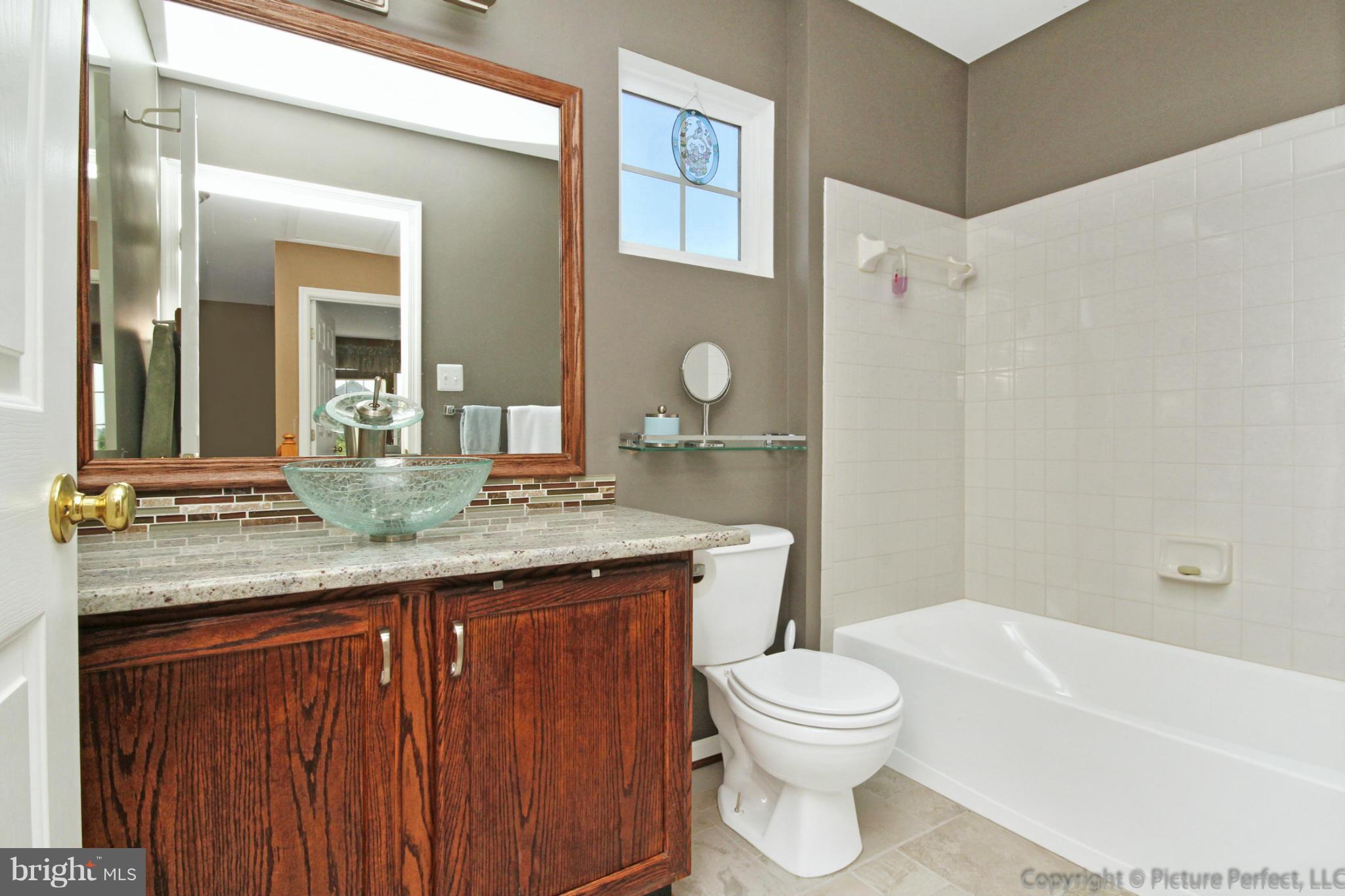9014 Bealls Farm Road Frederick, MD 21704 - Photo 13 of 30 a bathroom with a granite countertop sink toilet a mirror and bathtub