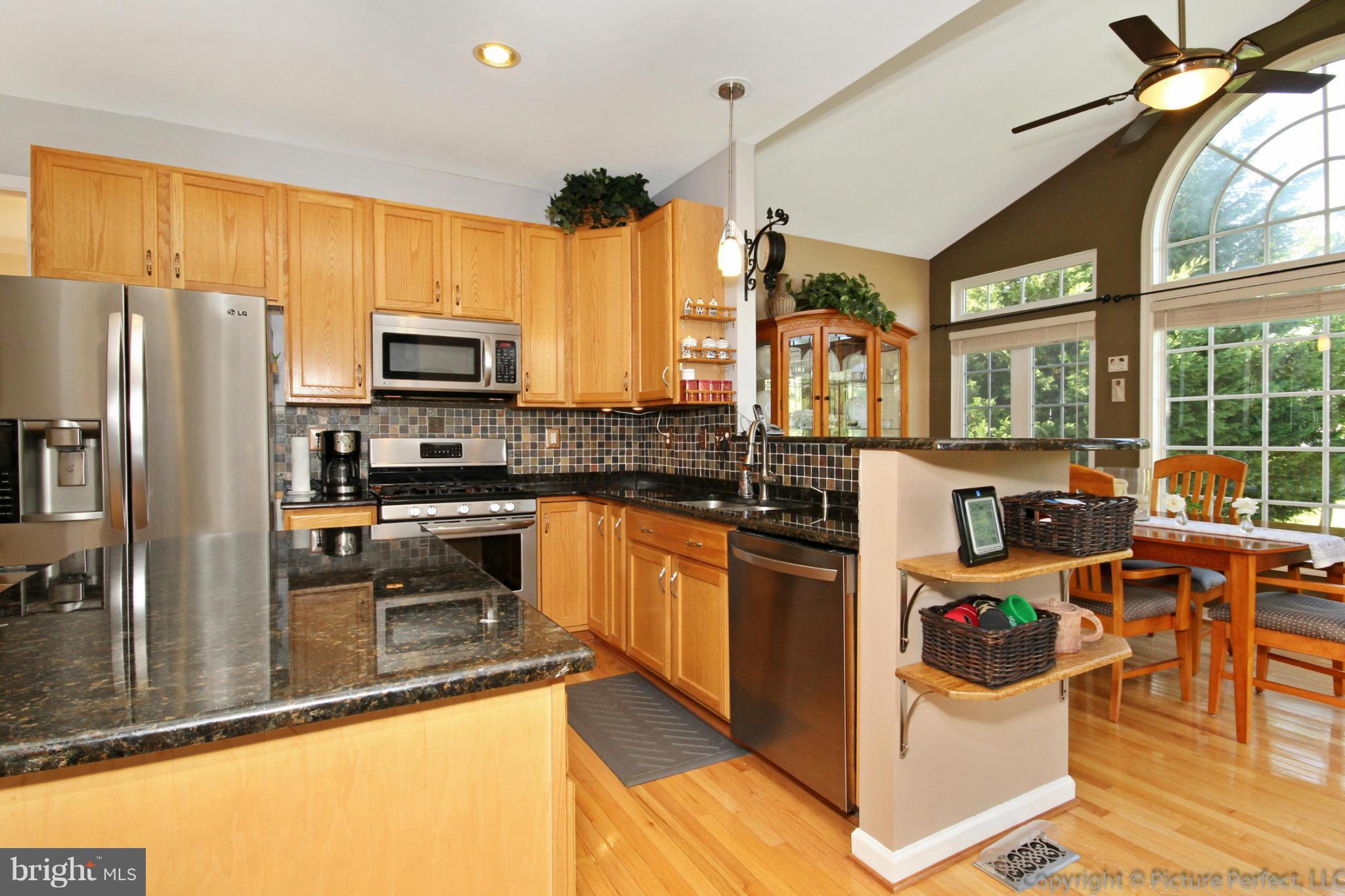 9014 Bealls Farm Road Frederick, MD 21704 - Photo 3 of 30 a kitchen with stainless steel appliances kitchen island granite countertop a refrigerator and a stove top oven with granite countertops