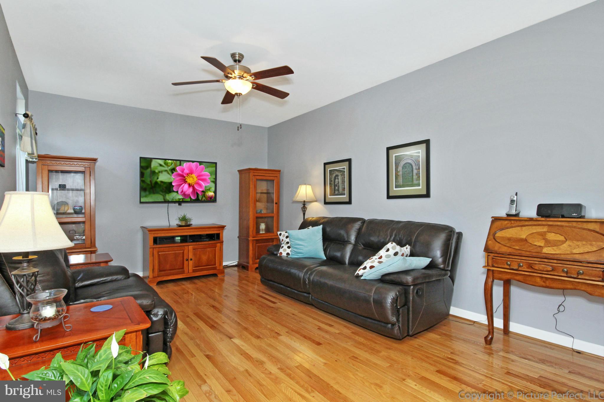 9014 Bealls Farm Road Frederick, MD 21704 - Photo 9 of 30 a living room with furniture a flat screen tv and a dining table with wooden floor