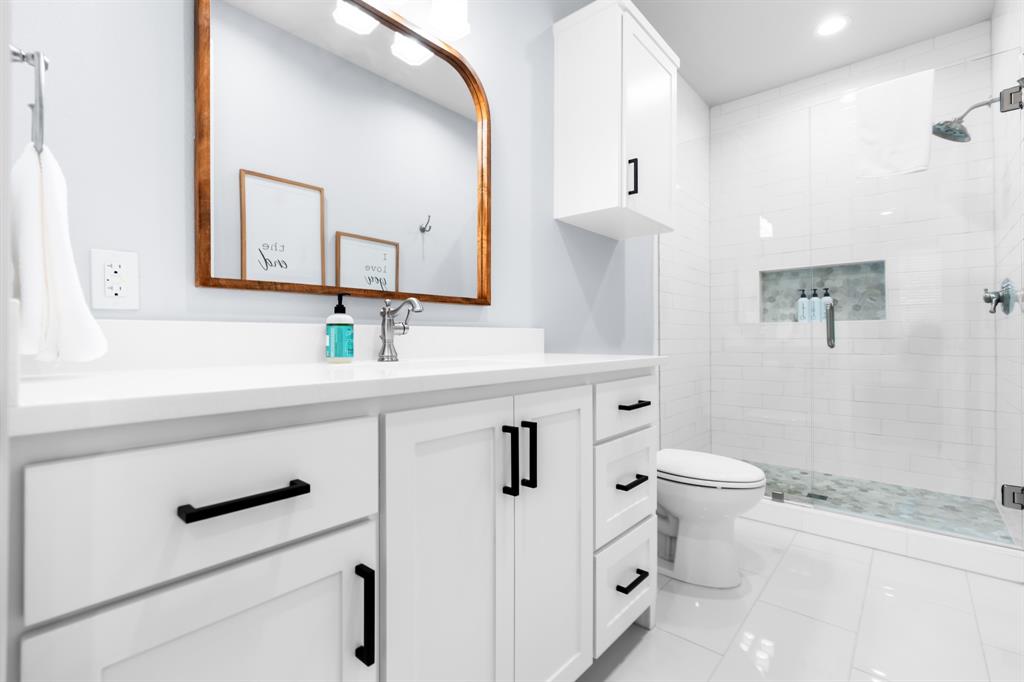 421 Proctor Avenue Waco, TX 76708 - Photo 16 of 28 a bathroom with a sink a toilet and a mirror