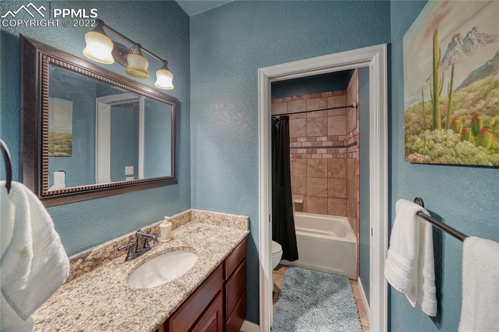 6205 Colfax Terrace Colorado Springs, CO 80906 - Photo 26 of 43 a bathroom with a granite countertop sink and a mirror