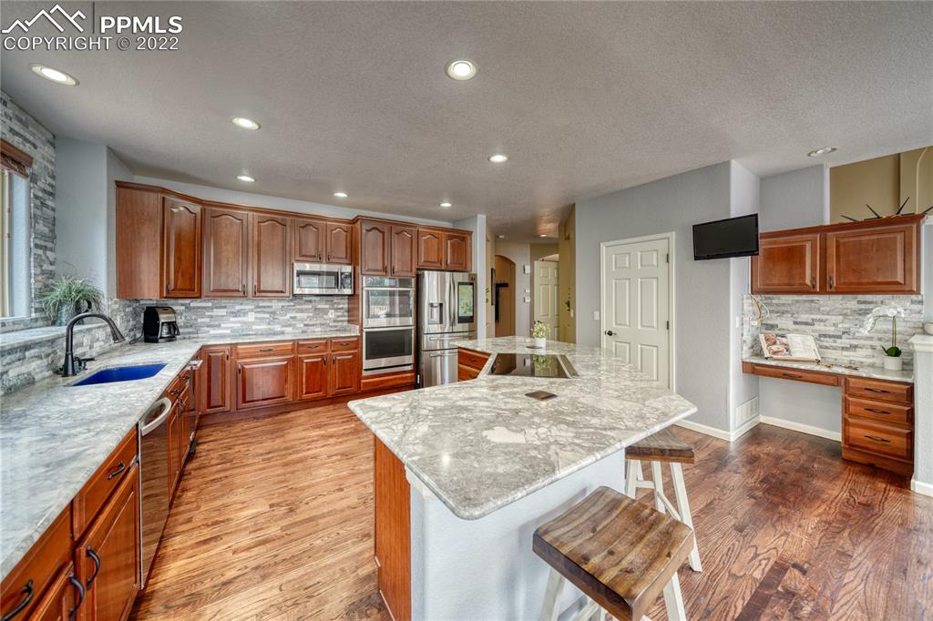 6205 Colfax Terrace Colorado Springs, CO 80906 - Photo 9 of 43 a kitchen with stainless steel appliances granite countertop a sink stove and refrigerator
