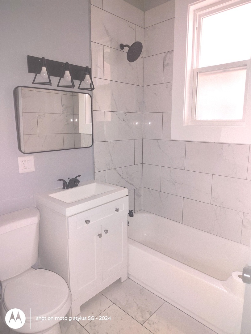 1661 South Homan Avenue, Unit 2 Chicago, IL 60623 - Photo 8 of 11 a bathroom with a sink a toilet and shower