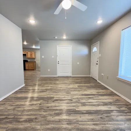 an empty room with wooden floor and chandelier