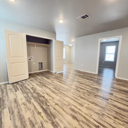 a view of empty room with wooden floor
