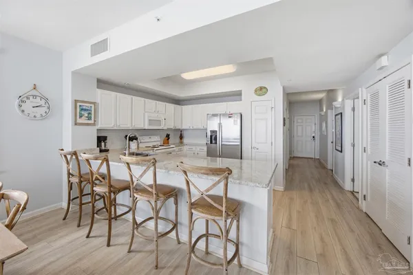 a kitchen with white cabinets stainless steel appliances and a center island