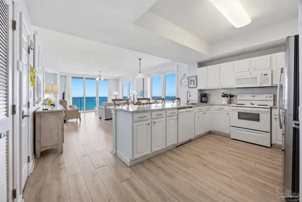 a large kitchen with cabinets wooden floor and stainless steel appliances