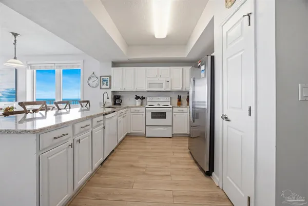 a kitchen with white cabinets and white stainless steel appliances