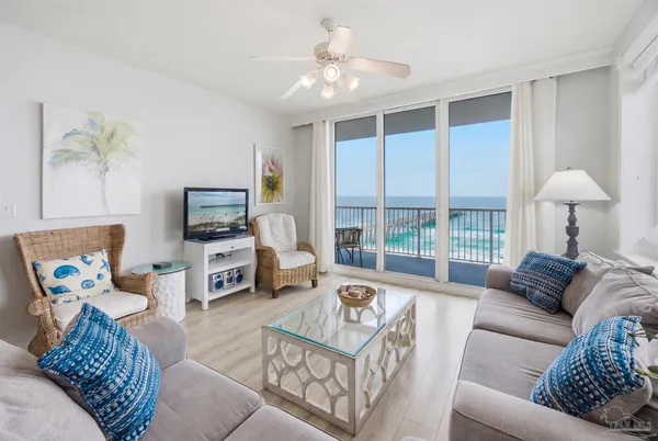 a living room with furniture kitchen view and a window
