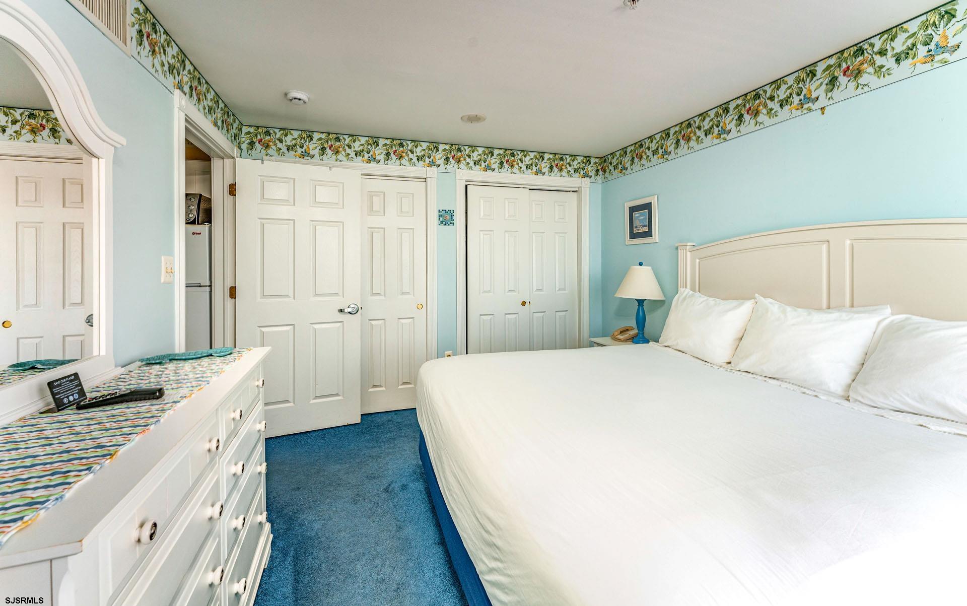 719 East 11th Street, Unit 810 Ocean City, NJ 08226 - Photo 11 of 25 a spacious bedroom with a large bed and a chandelier