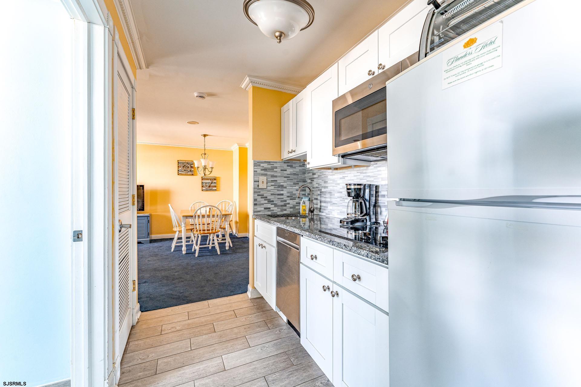 719 East 11th Street, Unit 810 Ocean City, NJ 08226 - Photo 8 of 25 a kitchen with stainless steel appliances granite countertop a sink and cabinets