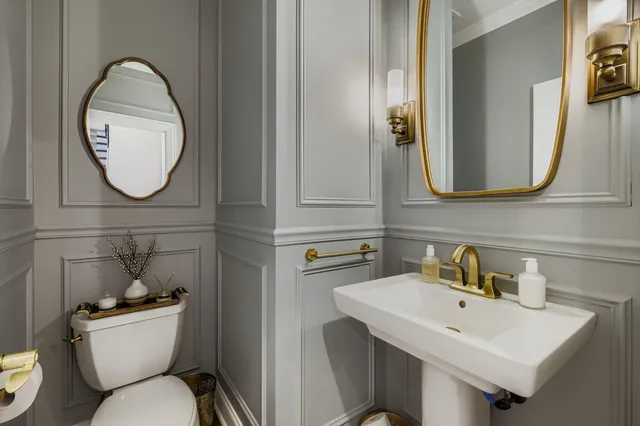a bathroom with a toilet a sink and a mirror