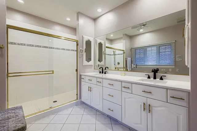 a bathroom with a double vanity sink mirror double shower and a mirror