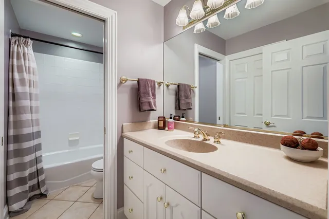 a bathroom with a granite countertop sink a mirror and a shower