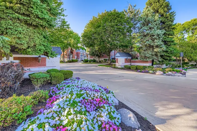 a front view of a house with a yard and fountain in middle