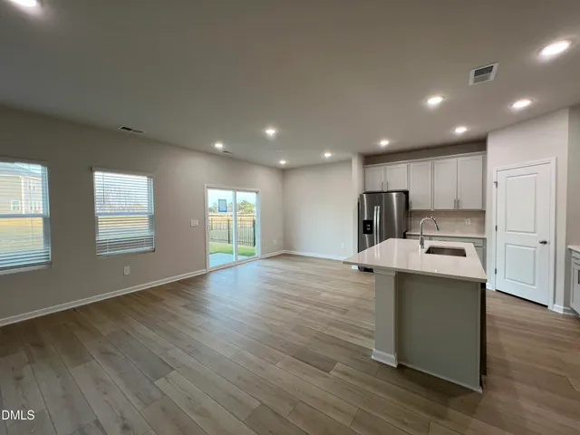 a kitchen with stainless steel appliances granite countertop a sink a stove and wooden floors