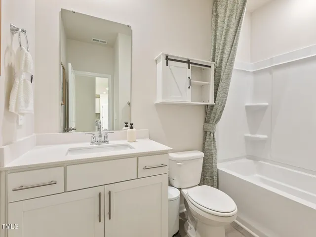 a bathroom with a sink toilet vanity mirror and bathtub