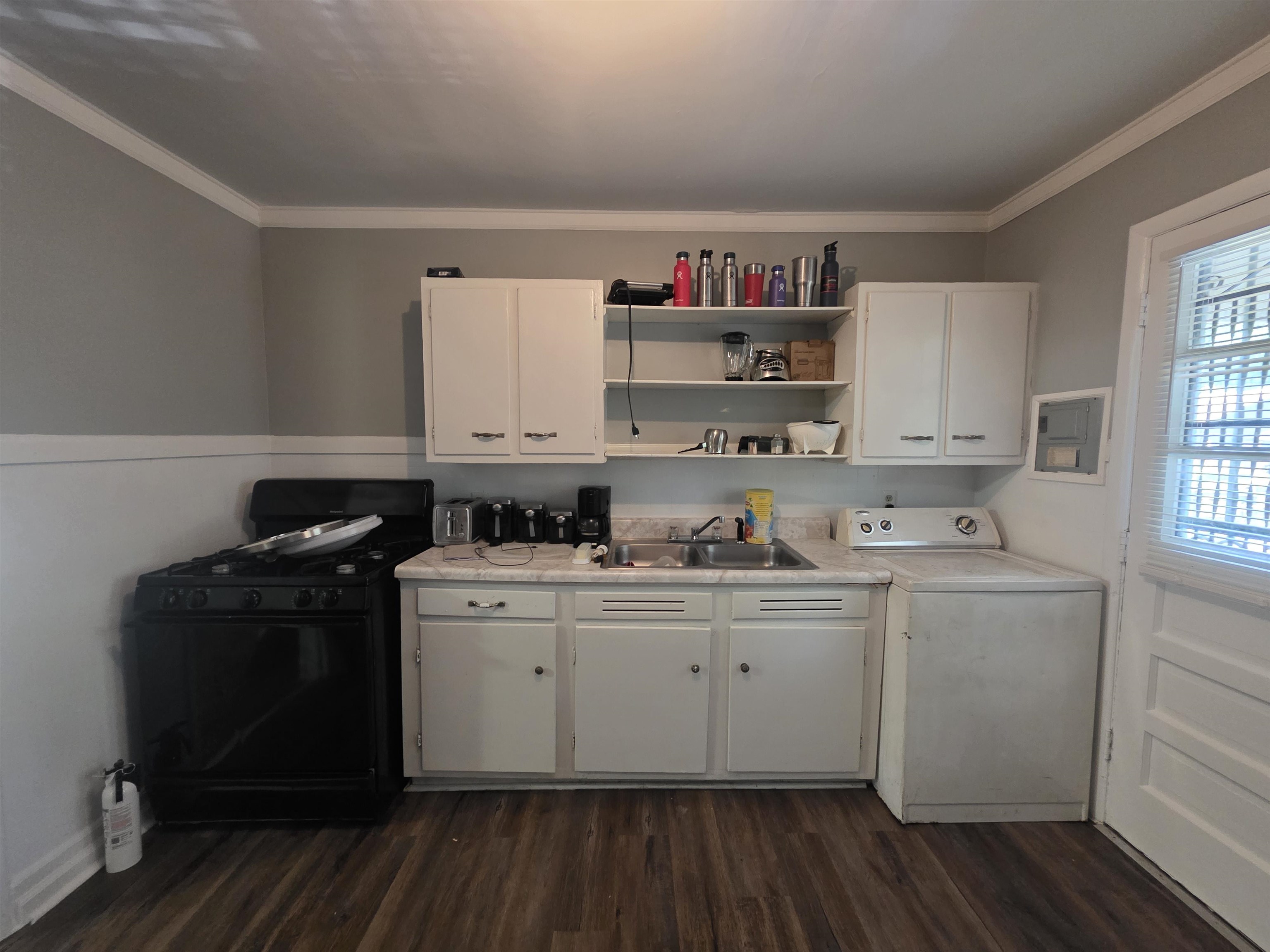 4072 Grey Road Memphis, TN 38108 - Photo 6 of 9 Kitchen area featuring wood-finish flooring, white cabinetry, a built-in sink, an electric range, and a built-in washer