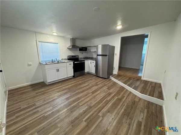 a kitchen with stainless steel appliances granite countertop a refrigerator sink and cabinets