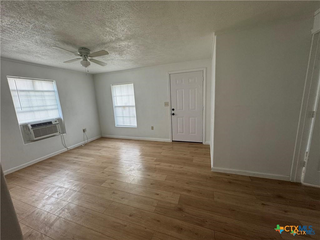 1209 Raymond Street Seguin, TX 78155 - Photo 2 of 11 an empty room with wooden floor and windows
