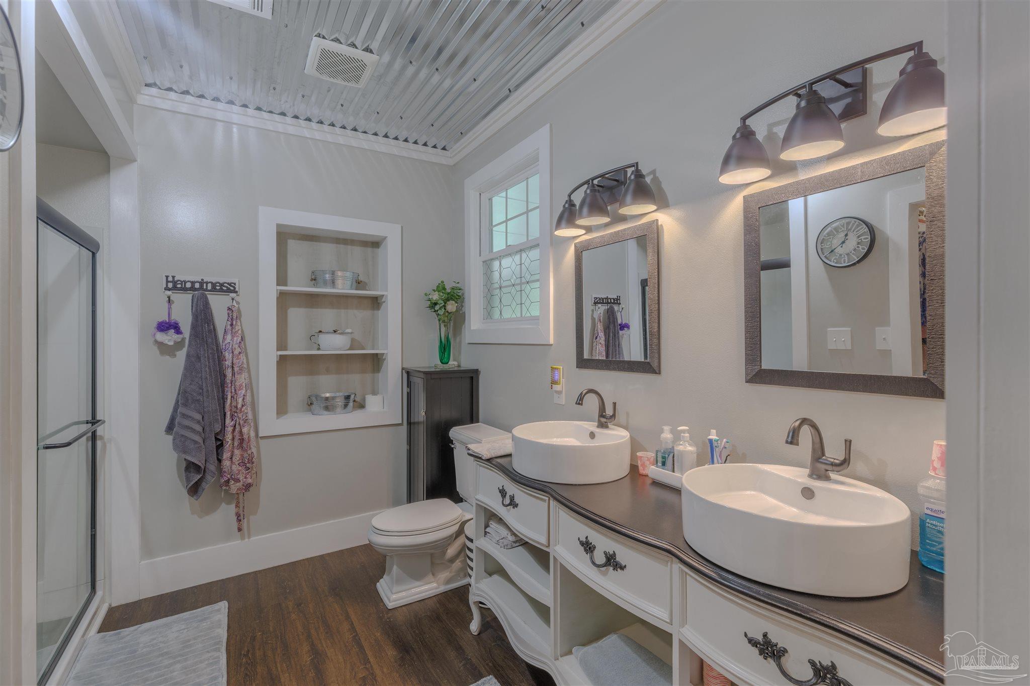 5049 Guernsey Road Pace, FL 32571 - Photo 38 of 61 a bathroom with a sink a toilet and a mirror